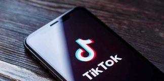 Phone screen showing TikTok logo and app.