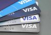 Stacked Visa credit cards in various colors.