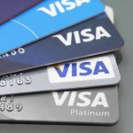 Stacked Visa credit cards in various colors.