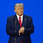 Trump Demands Clinton Probe—Epstein Emails Explode Man in a suit with a blue background.