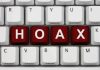Close-up of a computer keyboard with the word HOAX spelled out in red keys