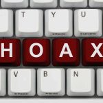 Close-up of a computer keyboard with the word HOAX spelled out in red keys