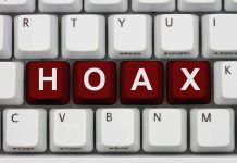 Close-up of a computer keyboard with the word HOAX spelled out in red keys