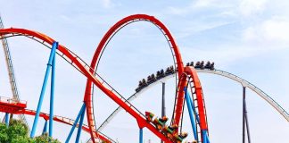 Colorful roller coaster with riders on a sunny day