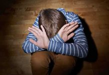 HORRIFYING Parent Betrayal—Cops Fooled, Child Pays A child sitting on the floor with their hands covering their face, expressing distress