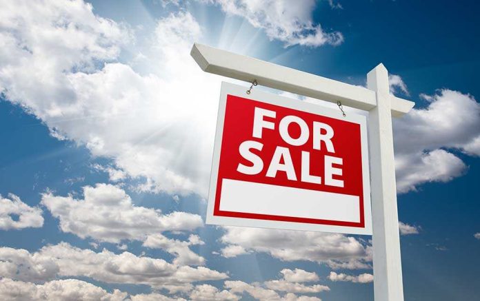 shutterstock_56496355.jpg A red For Sale sign against a blue sky with clouds