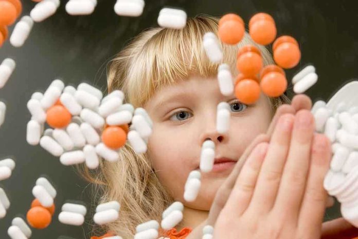 A child observing colorful pills floating in the air