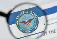 Magnifying glass over Department of Defense logo.