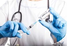 Hospital Horror: 38 Patients, One Trusted Doctor Doctor filling syringe with vaccine from vial.