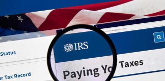 Magnifying glass over IRS website for paying taxes.