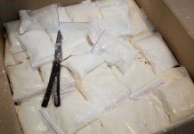 Mexico’s Government COLLAPSES Against Brutal Cartels Bags of white powder with scissors in cardboard box.