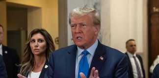 TRUMP Backs Controversial Military Decision Man speaking with hands raised, woman and security behind.