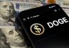 Crypto Kingpin CRUSHED – 15 Years, Billions Gone Smartphone displaying Doge logo on hundred dollar bills