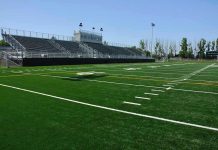 Football Scandal Explodes: Coach Arrested Empty football field with bleachers in background.