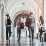 Four students walking in a corridor together.