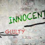 Blaze’s Reckless Accusation Wrecks Innocent Life Graffiti on a wall depicting the words 'INNOCENT' and 'GUILTY' with arrows