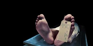 Feet of a deceased person on a coroners table with an identification tag