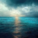 A serene ocean view with a dramatic sky and sunset reflection on the water