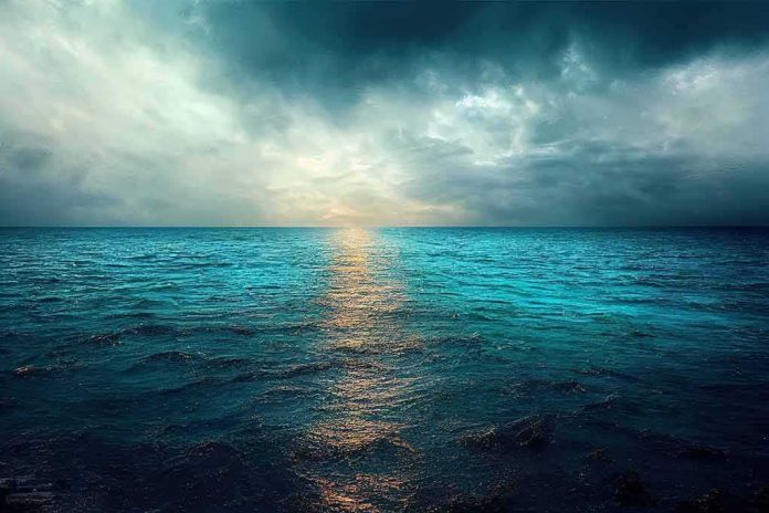 A serene ocean view with a dramatic sky and sunset reflection on the water
