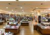 Interior view of a bookstore with shelves filled with books and wooden furniture