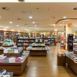 Interior view of a bookstore with shelves filled with books and wooden furniture