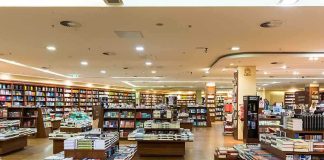 Interior view of a bookstore with shelves filled with books and wooden furniture