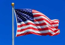 Waving American flag against a clear blue sky