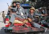 HORRIFYING Taliban Child Execution Shocks World Three armed soldiers sitting on the back of a military vehicle in an urban setting