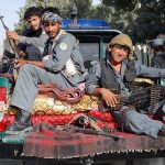 HORRIFYING Taliban Child Execution Shocks World Three armed soldiers sitting on the back of a military vehicle in an urban setting