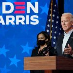 Two people speaking at a Biden Harris event.