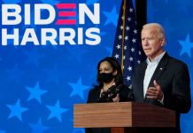 Two people speaking at a Biden Harris event.