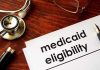 Audit Bombshell Hits NYC Medicaid Rides Stethoscope pen document about Medicaid eligibility on table