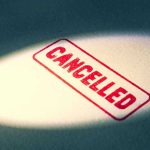 Red Cancelled stamp under a spotlight.