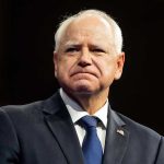 Man in suit with a U.S. flag pin.
