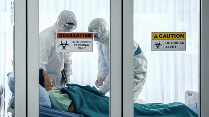 1647350797-1 Healthcare workers in protective gear in quarantine room.