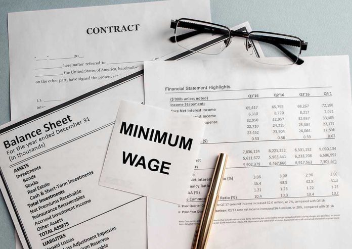 1716429175 Documents and glasses on table with Minimum Wage paper.