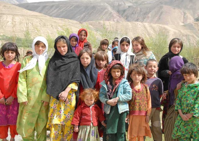 shutterstock_56953117 Group of children in colorful traditional clothing posing outdoors with mountains in the background