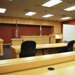 Hunter Biden’s Shocking Prostitution Claims Exposed Interior view of an empty courtroom with wooden furniture and American flags