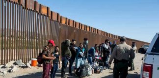 Watchdogs Expose Botched Child Tracking Border patrol agents interact with a group of people.