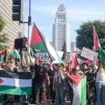 Hamas Rally Fallout Torches NY Race Protesters holding signs and flags in a public square.