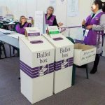 The Ballot Box Beat Democratic Party Politicians Again Election polling station with ballot boxes and officials.