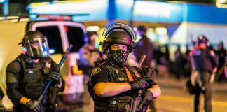 Times Square CHAOS — Shots In Broad Daylight Police officer in riot gear holding a weapon at night