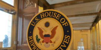 U.S. House of Representatives seal on glass door.