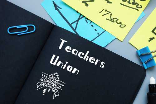 shutterstock_1746940400 A black notebook with 'Teachers Union' written on it, surrounded by colorful sticky notes and paper clips