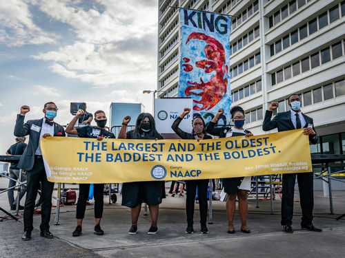 shutterstock_1756949327 Group of activists holding a banner at a protest event