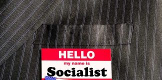 Socialism Alert Jolts Virginia Race Name tag on a pinstripe suit jacket pocket