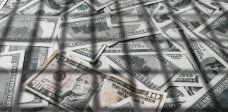 pile of us dollar bills with a ten-dollar note on top