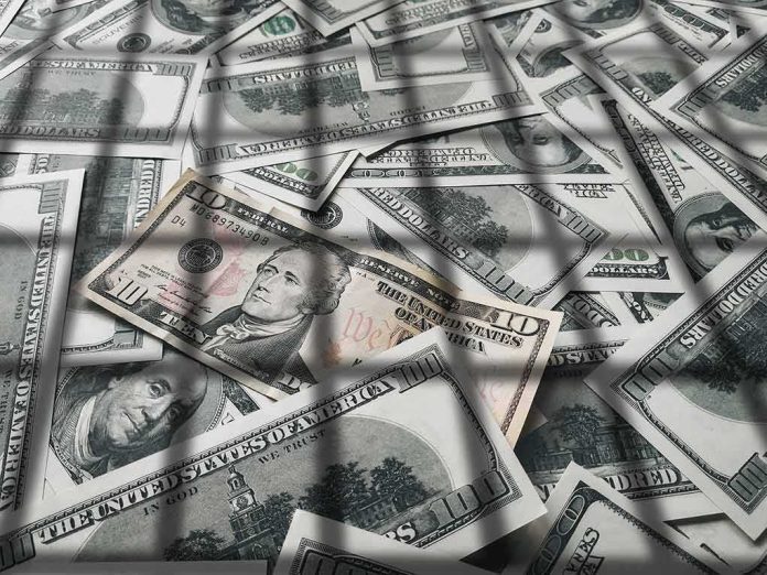shutterstock_1497524423 pile of us dollar bills with a ten-dollar note on top