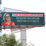 Outdoor billboard with a smiling woman in glasses and red dress