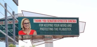 Outdoor billboard with a smiling woman in glasses and red dress